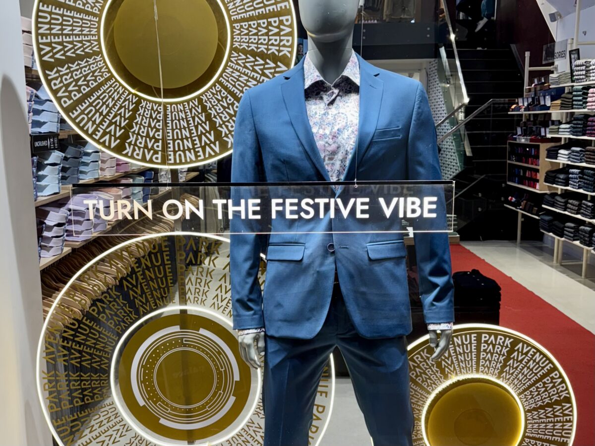 Butikkvindu med påskrift: Turn on the festive vibe